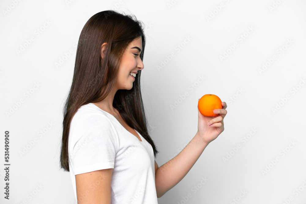 Young Brazilian woman holding an orange isolated on white background with happy expression Young Brazilian woman holding an orange isolated on white background with happy expression