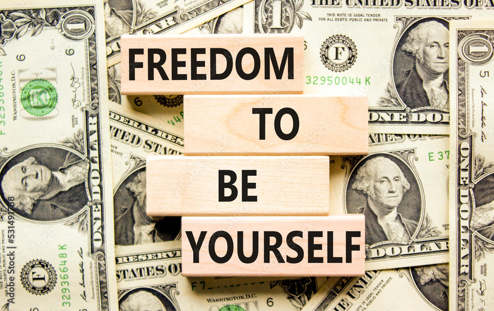 Freedom to be yourself symbol. Concept words Freedom to be yourself on wooden blocks on a beautiful background from dollar bills. Business, psychological freedom to be yourself concept.