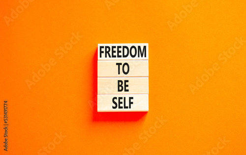 Freedom to be self symbol. Concept words Freedom to be self on wooden blocks on a beautiful orange table orange background. Business, psychological freedom to be self concept.