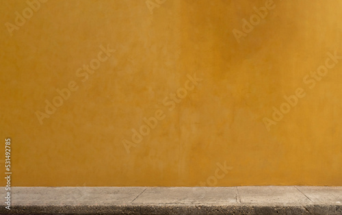 Colorful yellow wall of caribbean house with stucco texture for background.