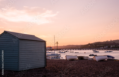 A rowing boat moored on Teignmouth's 'Back Beach' at sunset.