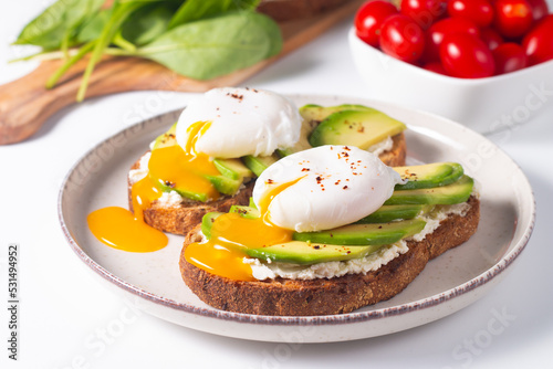 Two avocado open sandwiches with egg. Keto and diet concept. Healthy toast food for breakfast.