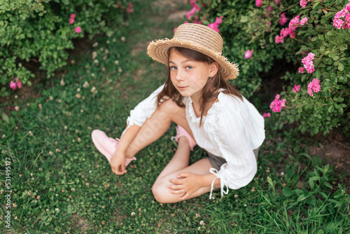 beautiful girl among pink roses outside