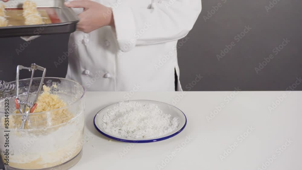 Scooping cookie dough into the baking sheet to bake coconut cookies. Scooping cookie dough into the baking sheet to bake coconut cookies.