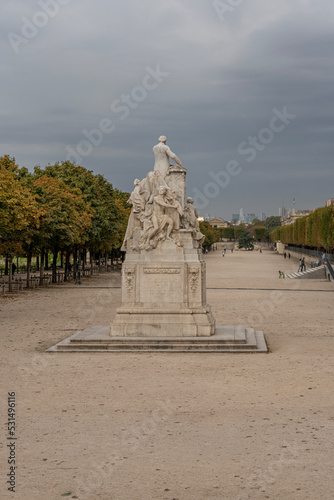 Paris, France - 09 16 2021: Tuileries garden. View of sculpture of Jules ferry in the park and La Defense buildings behind