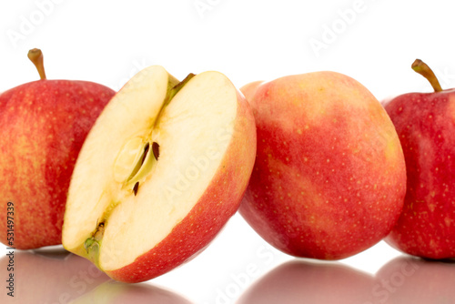 Two halves and two whole juicy red apples, macro, isolated on white background.