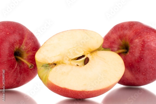 One half and two whole juicy red apples, macro, isolated on white background.