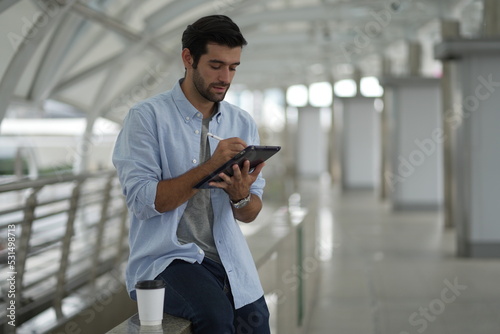 Young man freelancer traveler working online using laptop and enjoying the beautiful cityscape.