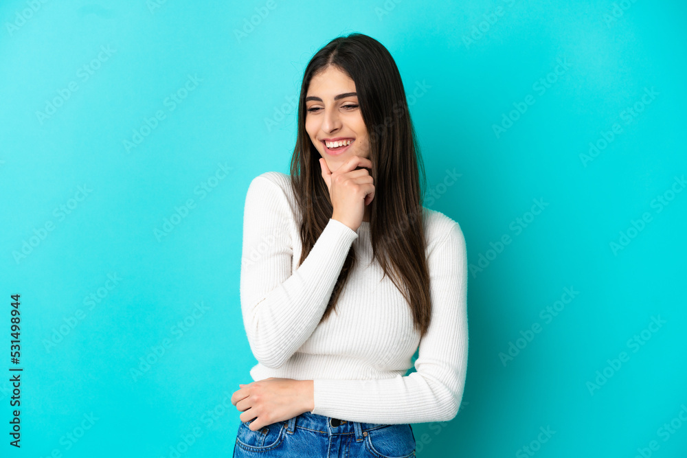 Young caucasian woman isolated on blue background looking to the side and smiling Young caucasian woman isolated on blue background looking to the side and smiling