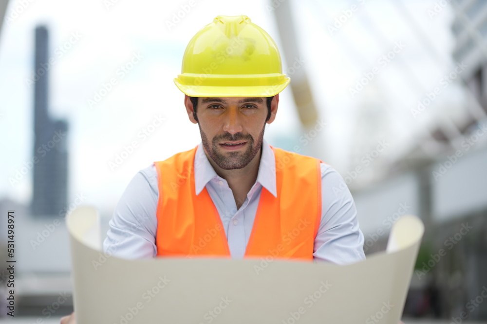 Architect or engineer with blueprints. Cauacsian Engineer checking plan on construction site. modern structure. helmet and blueprints paper. Architect or engineer with blueprints. Cauacsian Engineer checking plan on construction site. modern structure. helmet and blueprints paper.