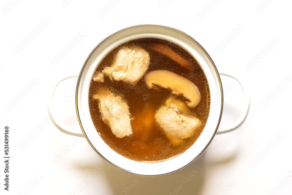 Pot of pork cartilage and shiitake mushroom soup with herbs isolated on white background. Pot of pork cartilage and shiitake mushroom soup with herbs isolated on white background.
