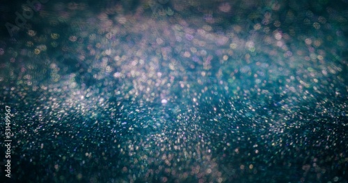 Particles background. Bokeh glitter light. Universe nebula. Defocused fluorescent purple blue color sparkles texture on dark abstract wallpaper.