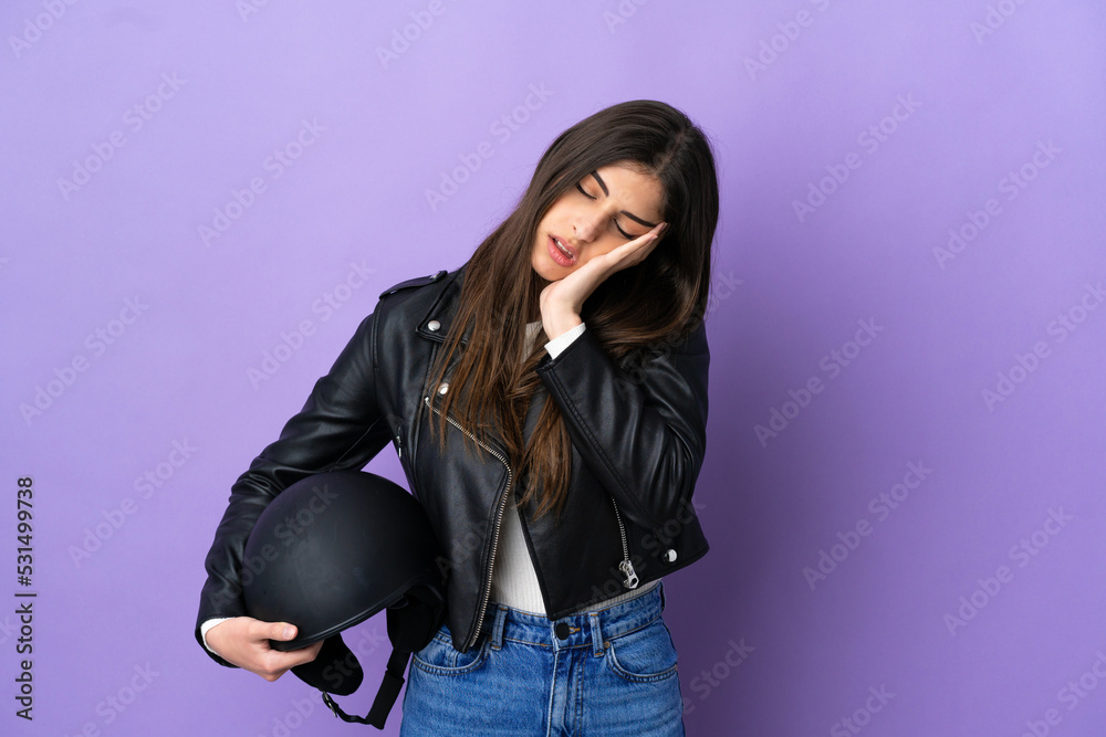 Young caucasian woman with a motorcycle helmet isolated on purple background with headache Young caucasian woman with a motorcycle helmet isolated on purple background with headache