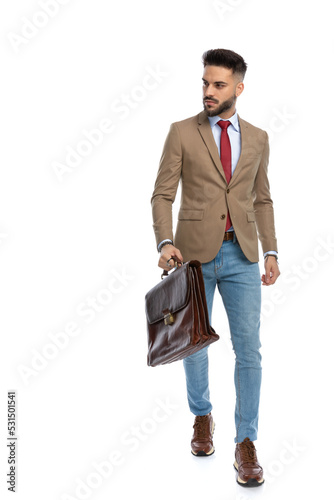 confident young man with red tie and suitcase looking to side photo