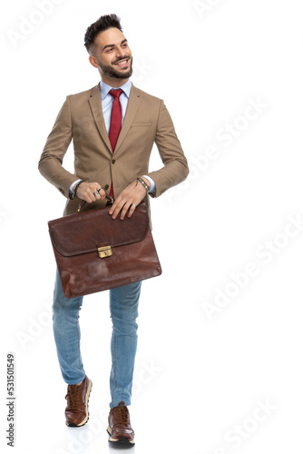 attractive young businessman with red tie holding suitcase photo