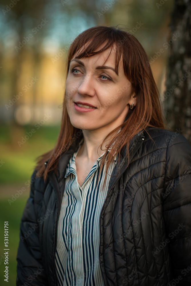 Portrait of a young beautiful red-haired girl in a spring park. There is artistic noise. Portrait of a young beautiful red-haired girl in a spring park. There is artistic noise.