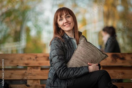 Portrait of a young beautiful red-haired girl in a spring park. There is artistic noise.