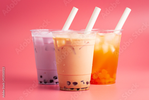 Three Different Types of Boba Tea on a Bright Pink Background
