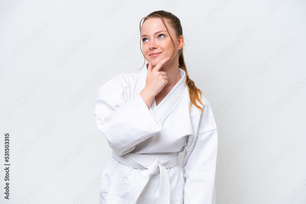 Young caucasian girl doing karate isolated on white background having doubts Young caucasian girl doing karate isolated on white background having doubts