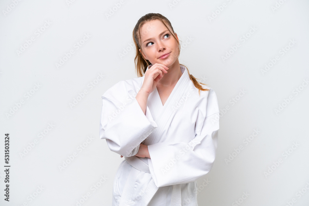 Young caucasian girl doing karate isolated on white background and looking up Young caucasian girl doing karate isolated on white background and looking up