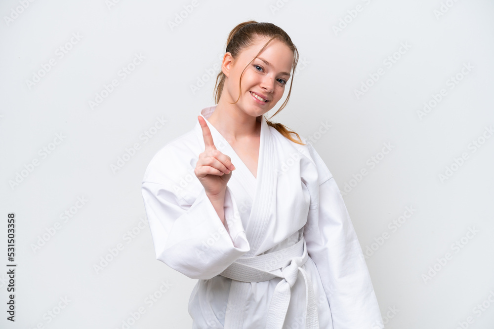 Young caucasian girl doing karate isolated on white background showing and lifting a finger Young caucasian girl doing karate isolated on white background showing and lifting a finger