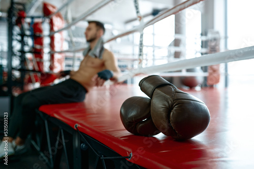 Selective focus on boxing glove, boxer blurred background
