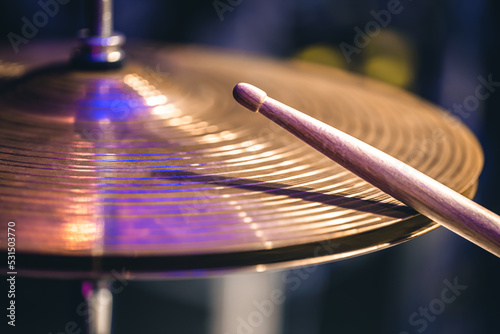 Hi-hat close-up of plates with drumsticks on a background of colored lanterns. photo