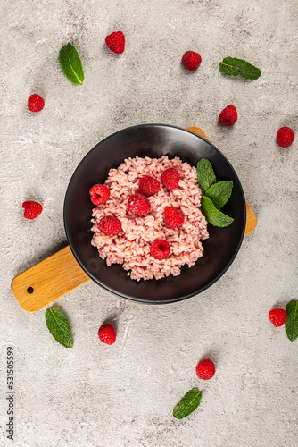 risotto with raspberries and greek yogurt on grey background.