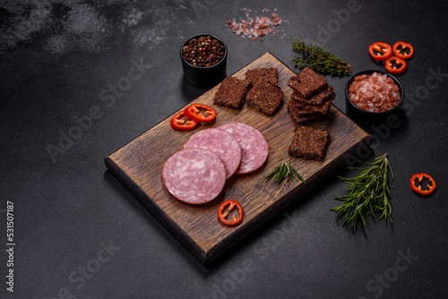 Delicious fresh smoked sausage cut with slices on a wooden cutting board