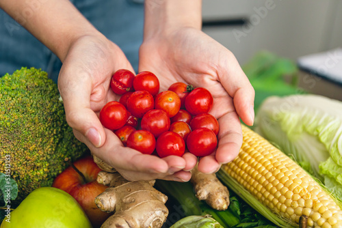 Small cherry tomatoes in women's hands on a blurred background.