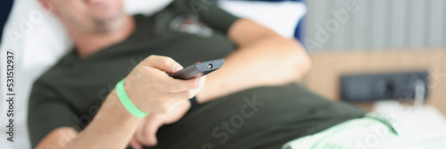 Smiling lying man with remote control closeup