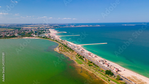 Aerial photography taken from a drone at Eforie beach with Techirghiol lake on the left side of the beach and the Black sea on the right side. A patch of land between sea and lake.