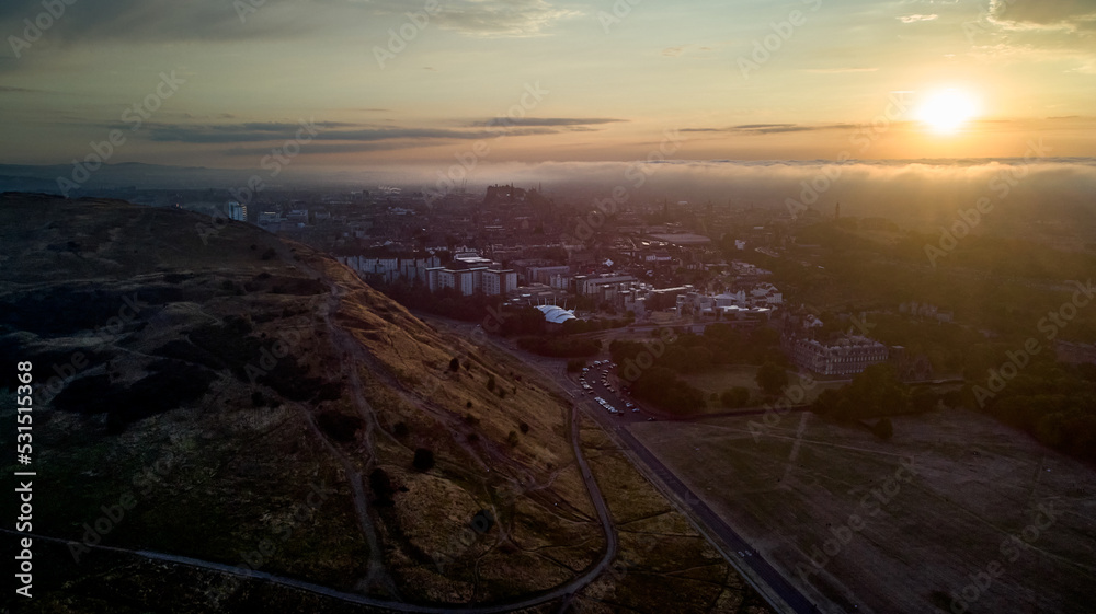 Aerial view of Edinburgh at sunset. Edinburgh Castle can be seen at distance in the clouds
