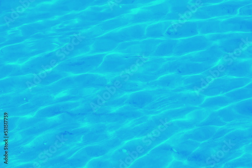 Water ripple texture background. Wavy water surface. Blue sky reflected in the water.