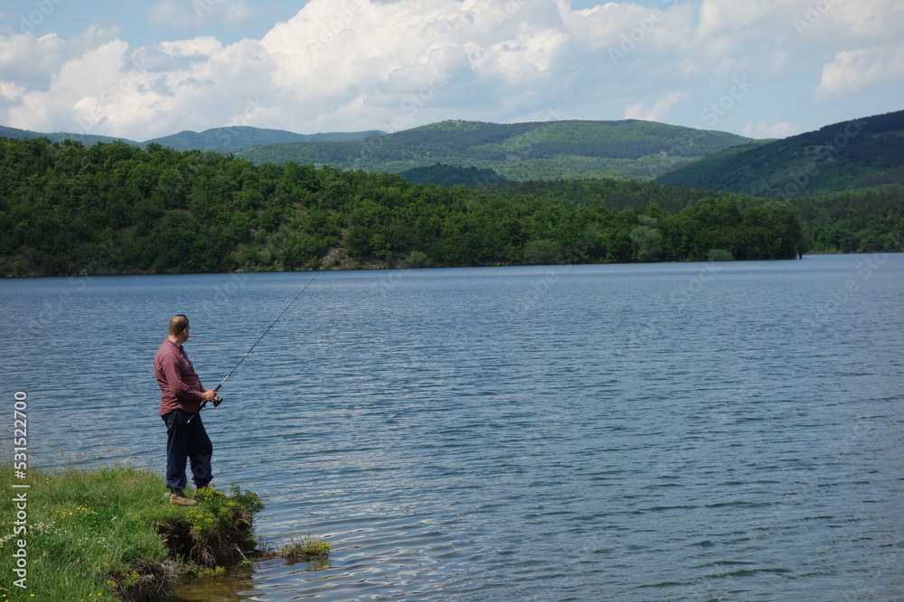 a lone fisherman catches fish on the shore