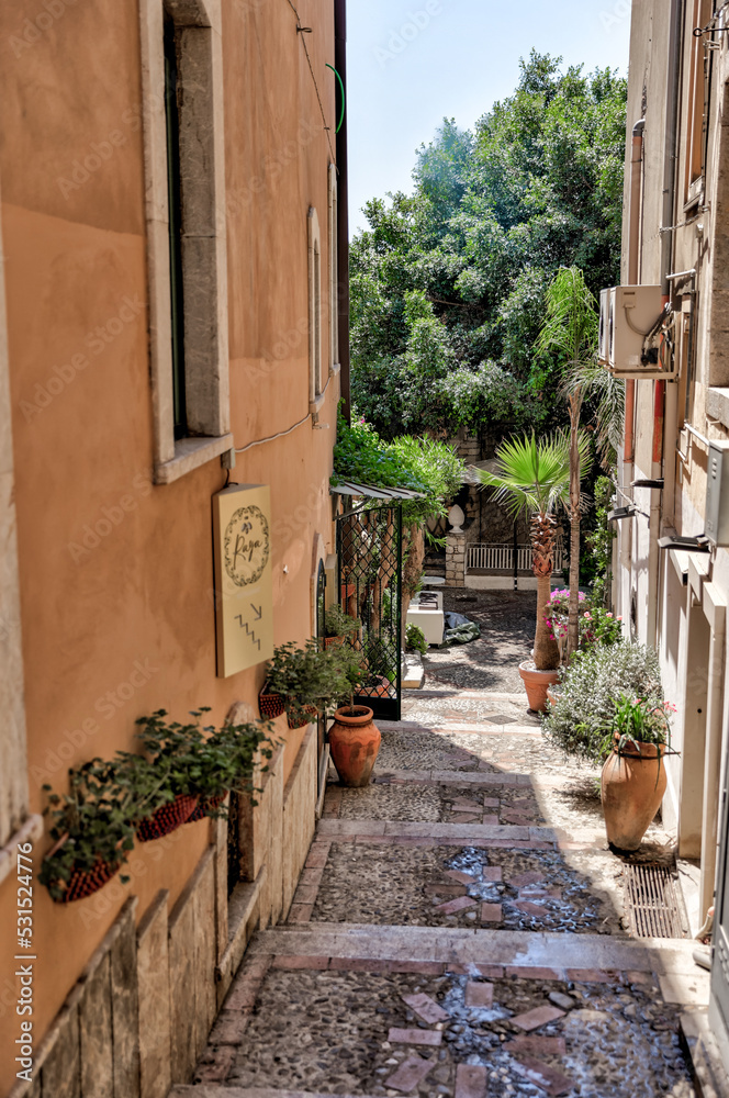 Naklejka premium Taormina, Italy - July 22, 2022: Scenic streets and sidewalks in Taormina, Sicily 