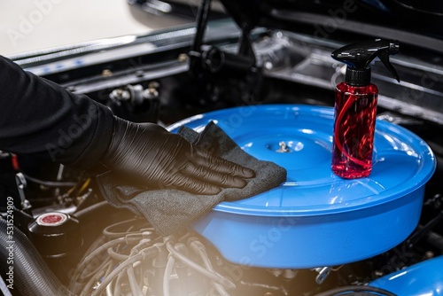 Obraz na płótnie Car mechanic or car wash worker will clean the car engine with a cloth. Car care w salonie
