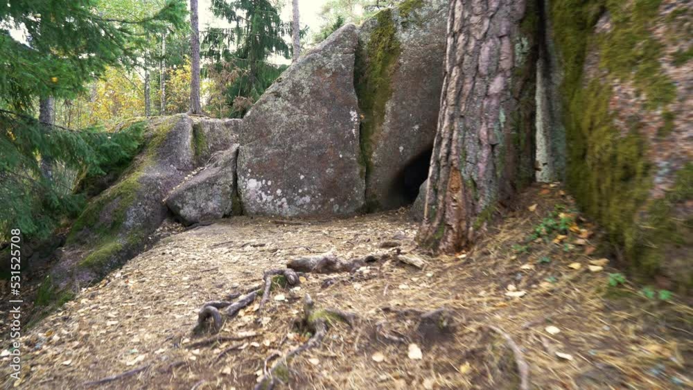 Exploring ancient natural monument Hogberget Cave in the forest, South Finland.