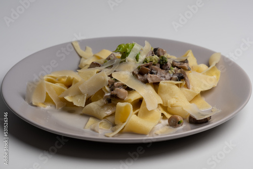 gray plate with delicious pasta with mushrooms, broccoli and parmesan cheese in a cream sauce. food background.