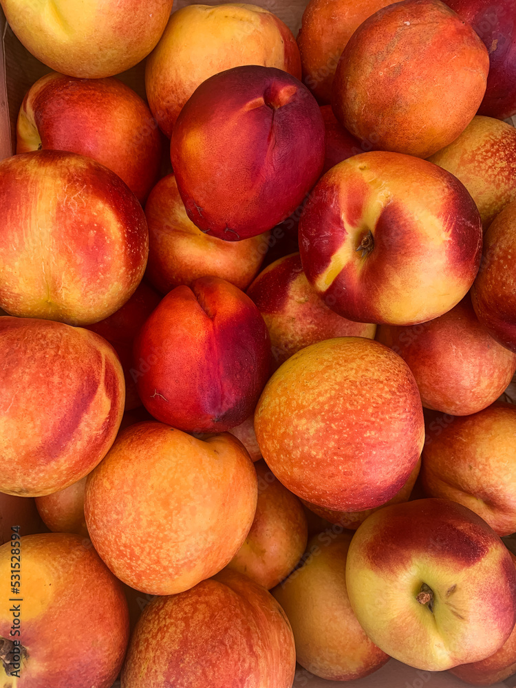 Close-up of Organic Nectarines at Outdoor Farmer's Market. Fresh nektarine on the market. Full frame of a crate of yellow nectarines. Close-up of Organic Nectarines at Outdoor Farmer's Market. Fresh nektarine on the market. Full frame of a crate of yellow nectarines.