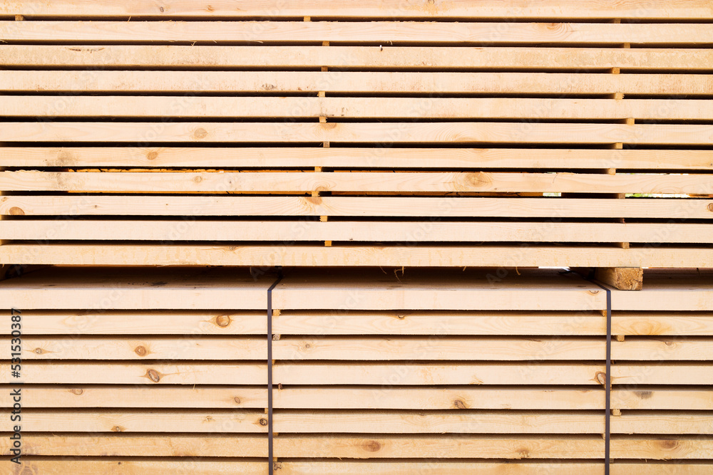 Background from wooden boards close-up. Stacked stacks of wooden planks. Lumber warehouse, wood drying, building material. Background from wooden boards close-up. Stacked stacks of wooden planks. Lumber warehouse, wood drying, building material.