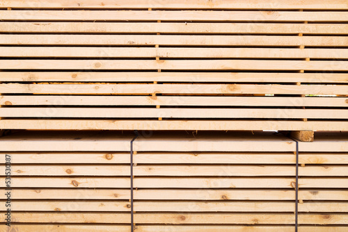 Background from wooden boards close-up. Stacked stacks of wooden planks. Lumber warehouse  wood drying  building material. 