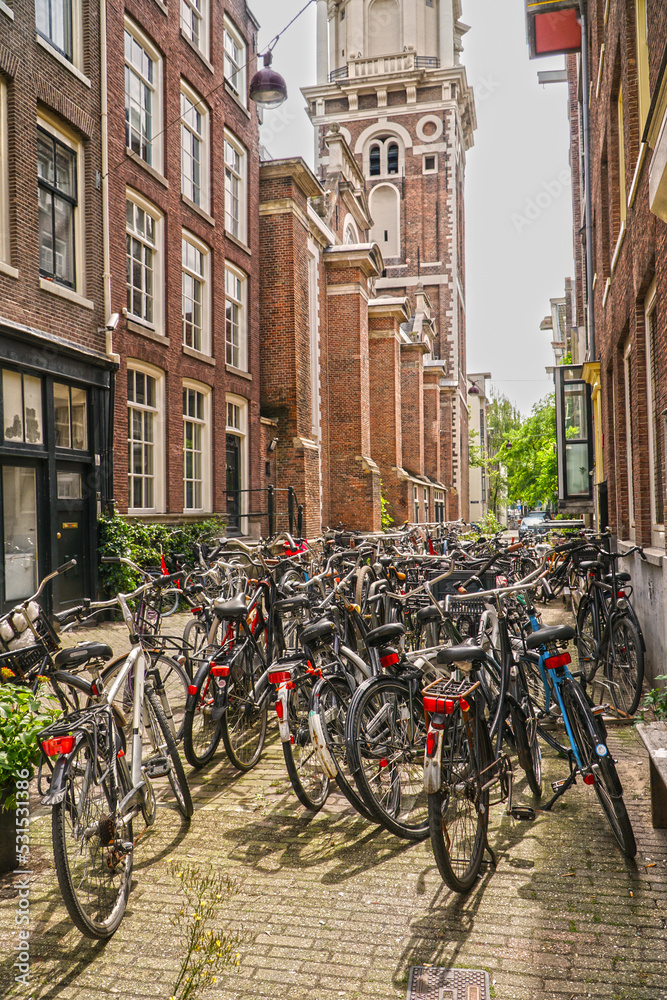 Bikes parked on the street in Amsterdam with the view on Dutch architecture. 