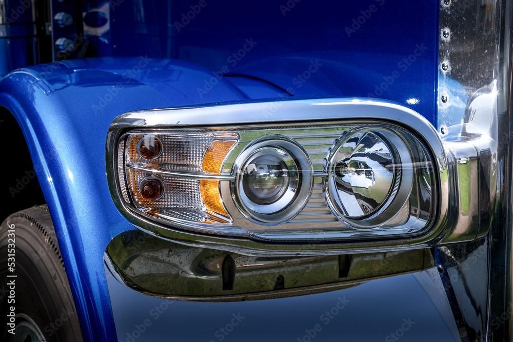 The unique headlight of a Semi Truck.  A breathtaking blue truck with stunning teardrop headlights at a truck show in Upstate NY.