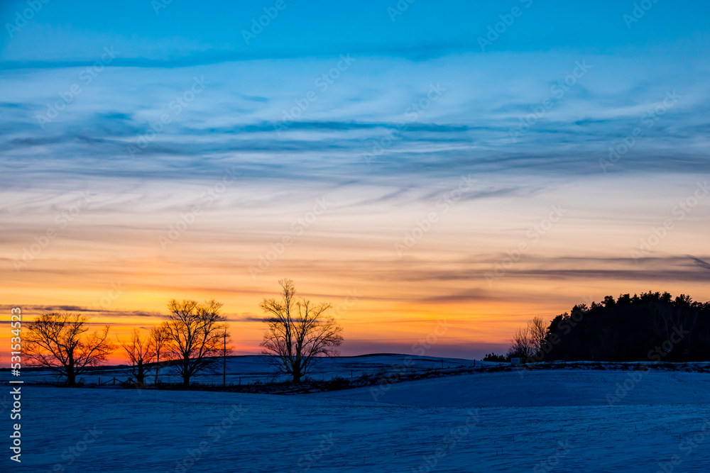 Obraz premium Windswept, Winter Farmland at Sunset in Adjala–Tosorontio, Ontario