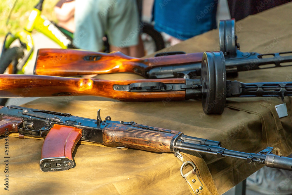 An old Kalashnikov assault rifle lies on the table next to a Soviet ...