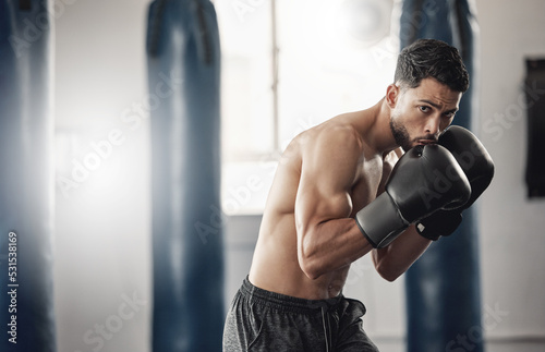 Boxing gym, man portrait and boxer pose technique for protection in mma fight practice studio. Exercise, fitness and athlete focus training for kickboxing safety and wellness preparation. © Beaunitta V W/peopleimages.com