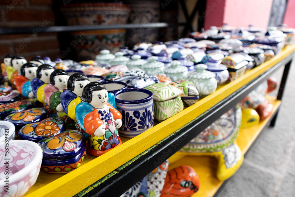 mexican talvaera ceramica colorful traditional pottery cups and souvenirs in a market