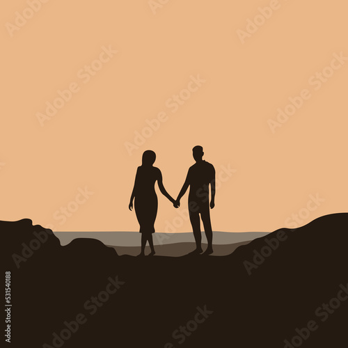 Silhouette of a man and a woman standing on the beach and watching the sunset