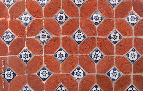 traditional mexican red wall  with blue details adornments of handmade hand painted talavera poblana tiles in Atlixco, Puebla city, Mexico photo